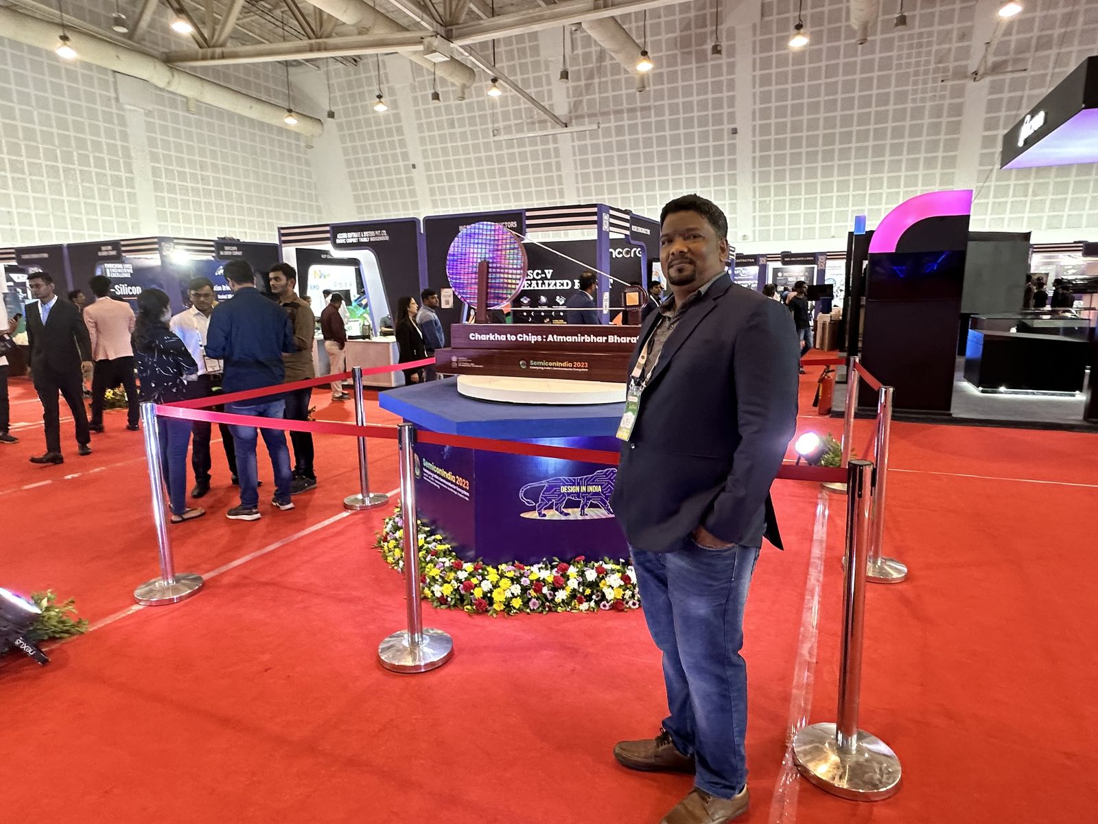 Venkatesh Kumar Pandurengan on the exhibition floor at SEMICON India beside the Charkha to Chips display